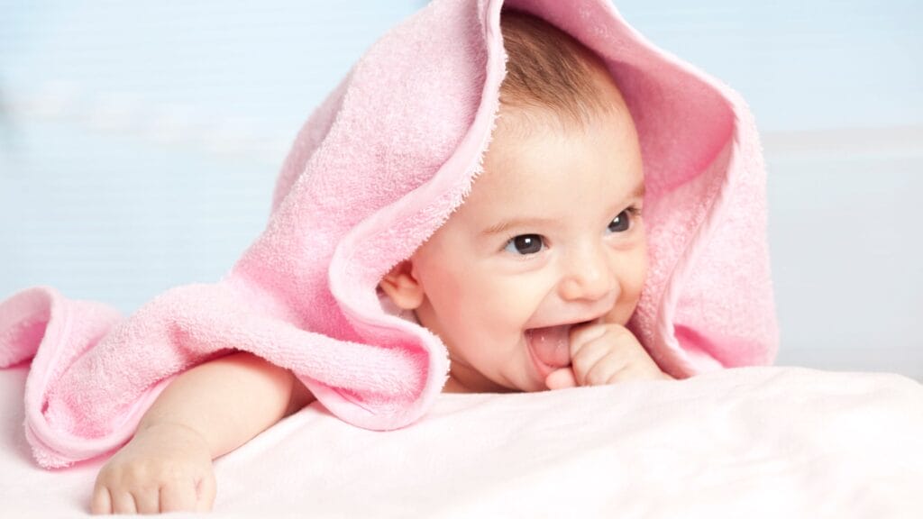 Infant wrapped in pink towel.